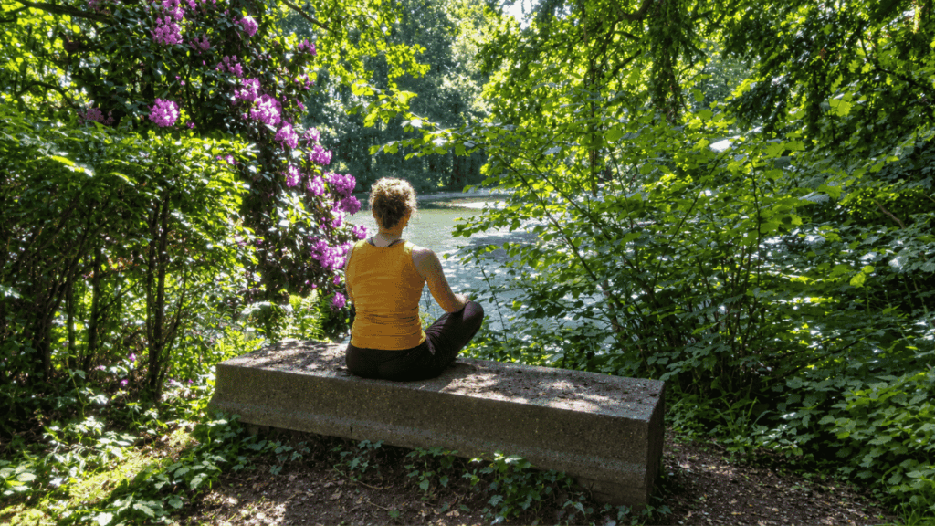 Vrouw zit in stilte op de steen tussen de bomen bij De Refter